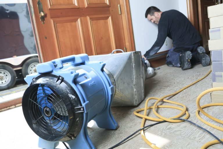 A technician cleaning a section of ductwork